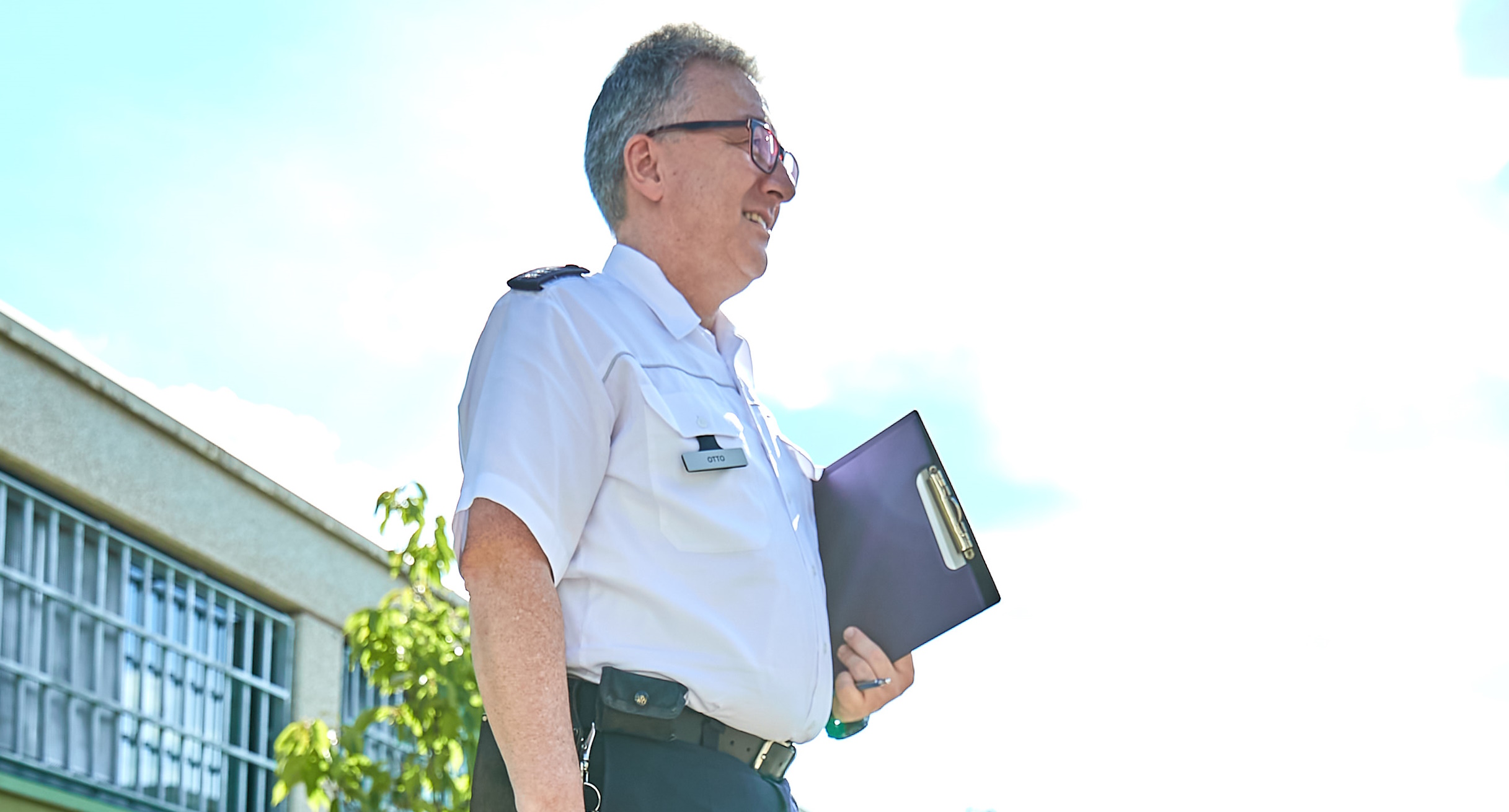 Ein Beamter mit Info-Mappe der Justizvollzugsanstalt Ravensburg